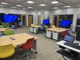 Sandbox room with mobile tables, chairs, and monitors
