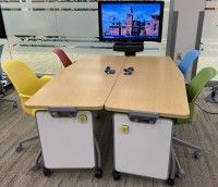 Sandbox student station consisting of tables, chairs, small whiteboards, and display monitor